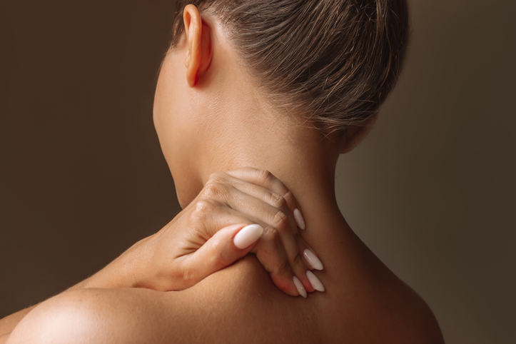 Woman massaging tight shoulder muscles as magnesium is an aid not a solution